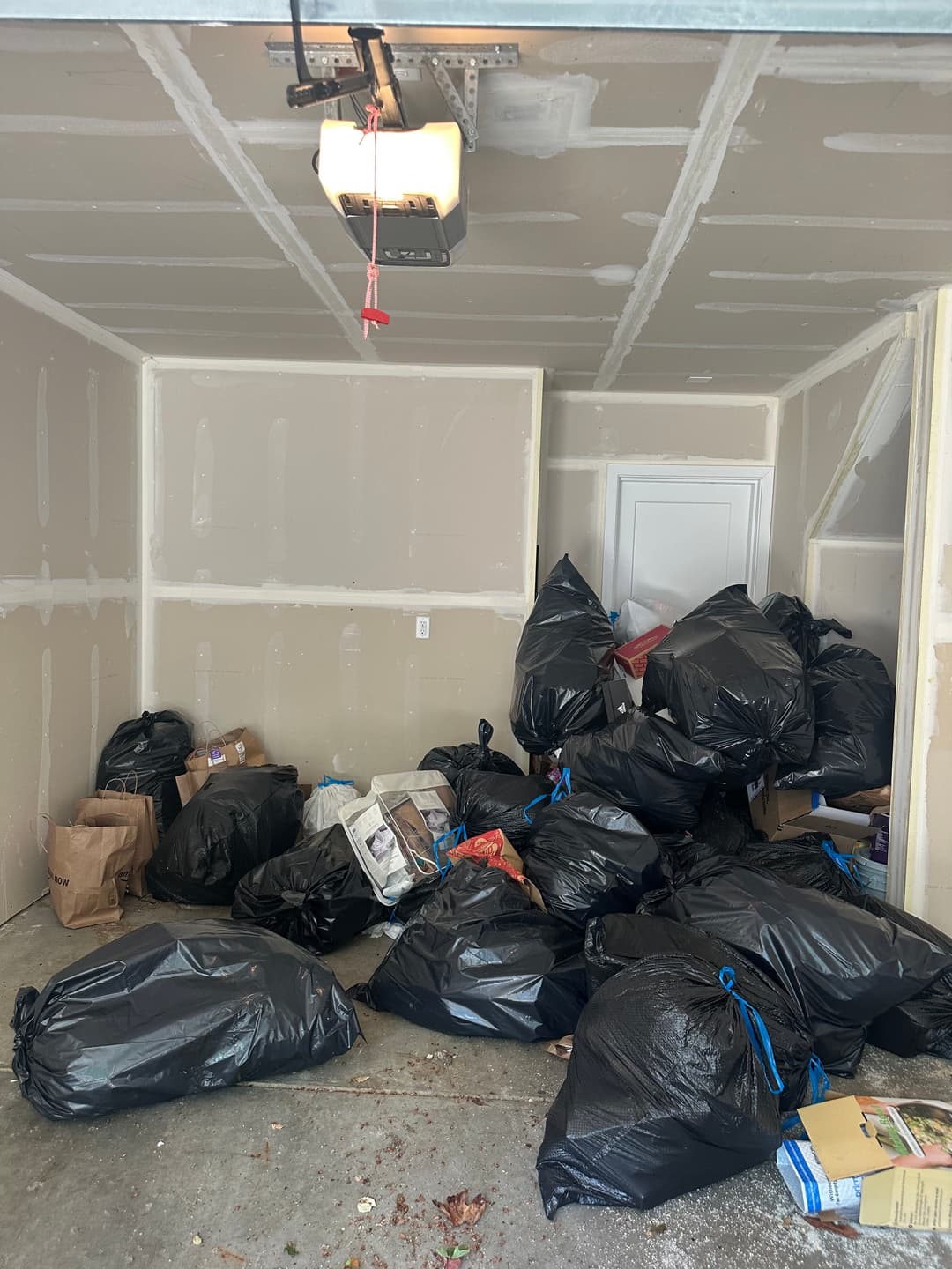 Garage corner filled with bagged junk ready for hauling after a garage cleanout